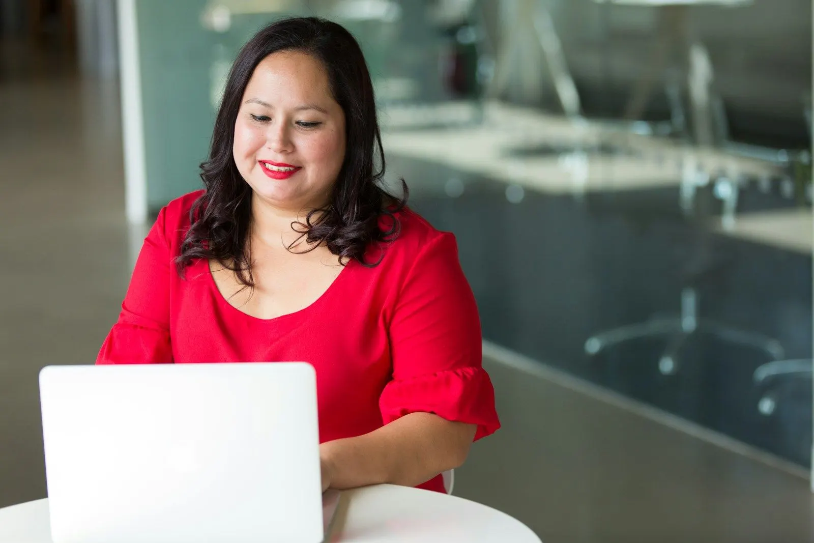 A product manager works on a laptop in a bright office, embedded with the team.