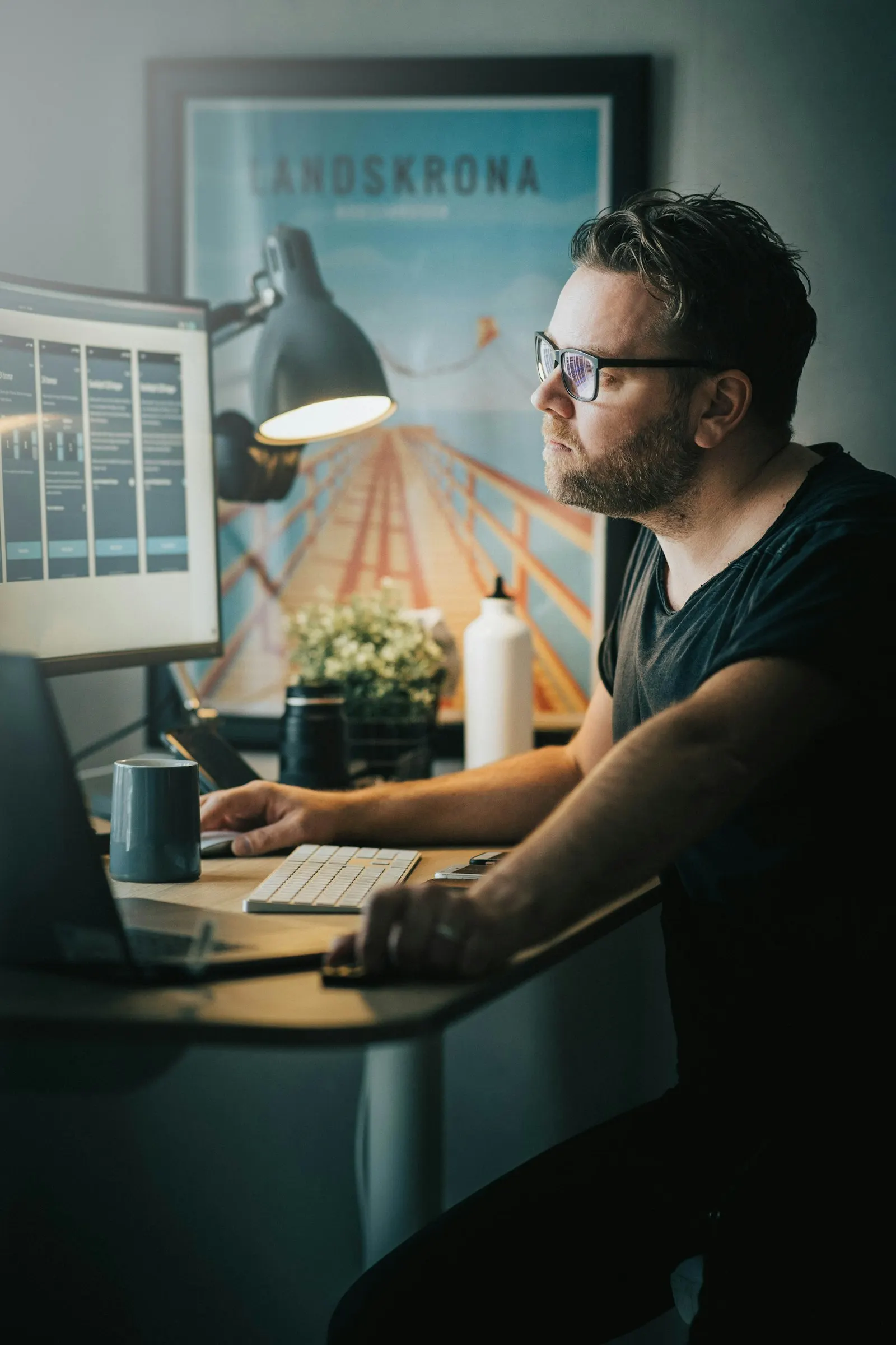 A React developer studying a component layout on his monitor at a home-office desk.