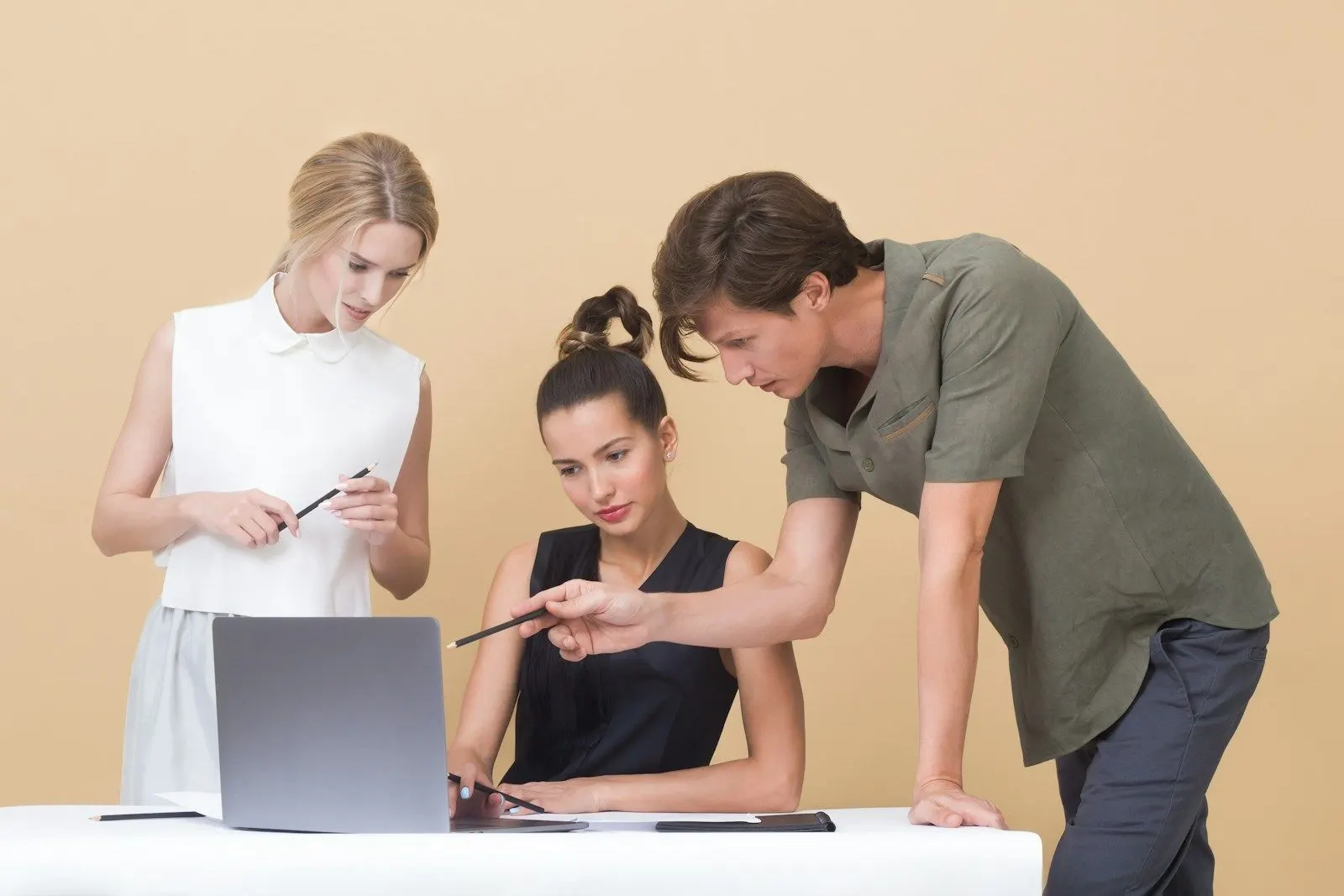 Two colleagues discussing how to hire a fullstack developer around a laptop.