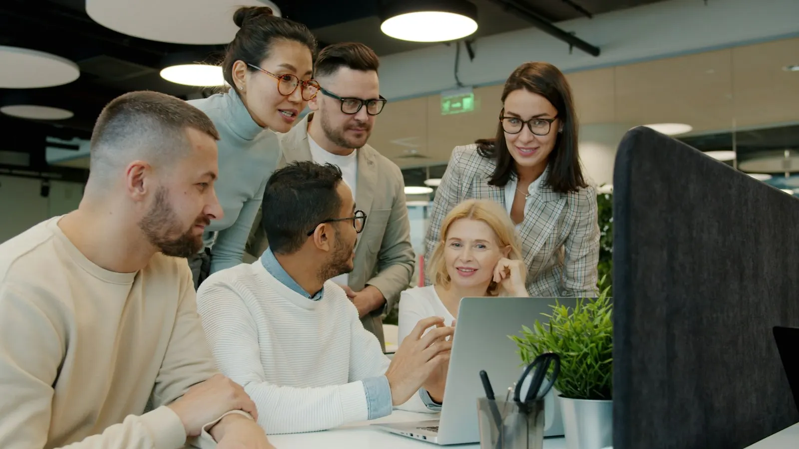 A Node.js team gathering around a laptop to review a service together.
