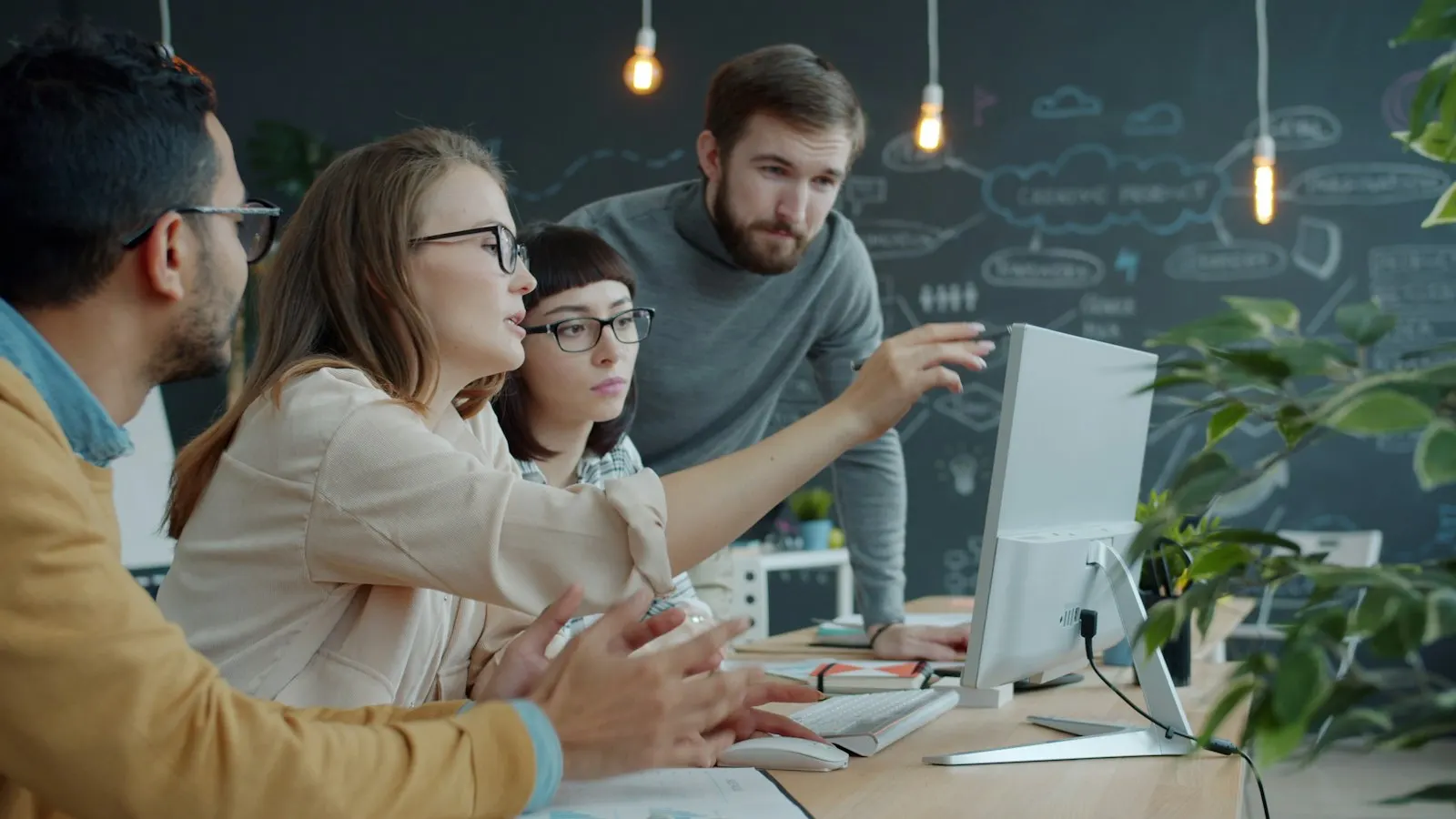 A Python team discussing a service on a monitor in a studio office.