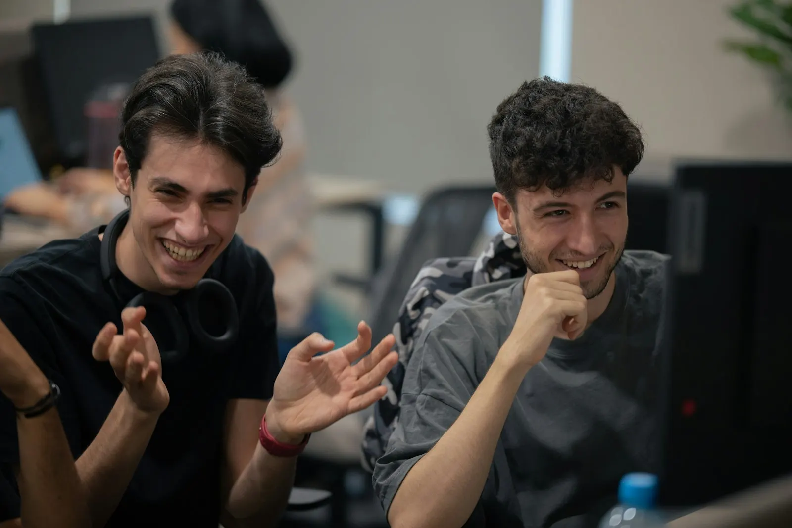 Two Java developers talking through a service at their desks.