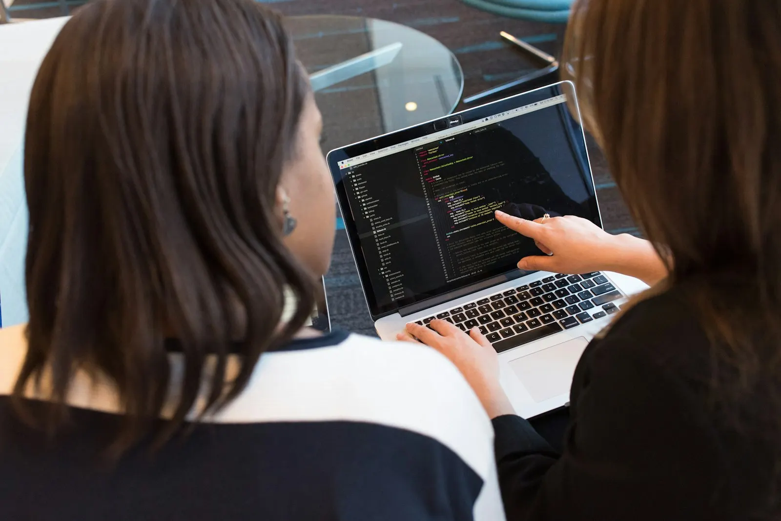Two Kotlin developers reviewing code together on a laptop.
