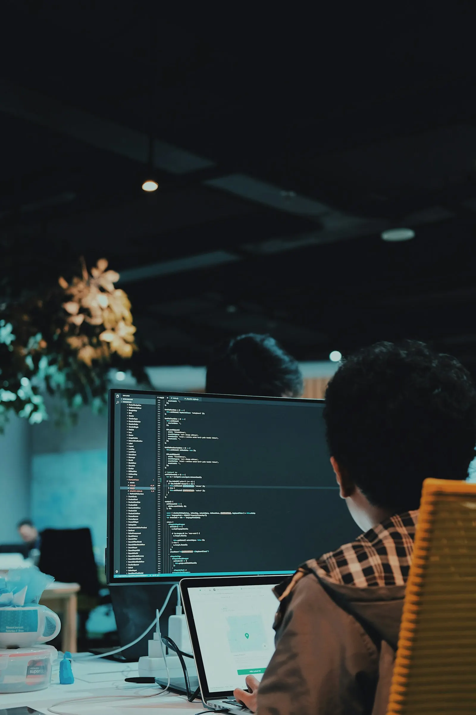 A Kotlin engineer writing code at a desktop monitor in an open office.