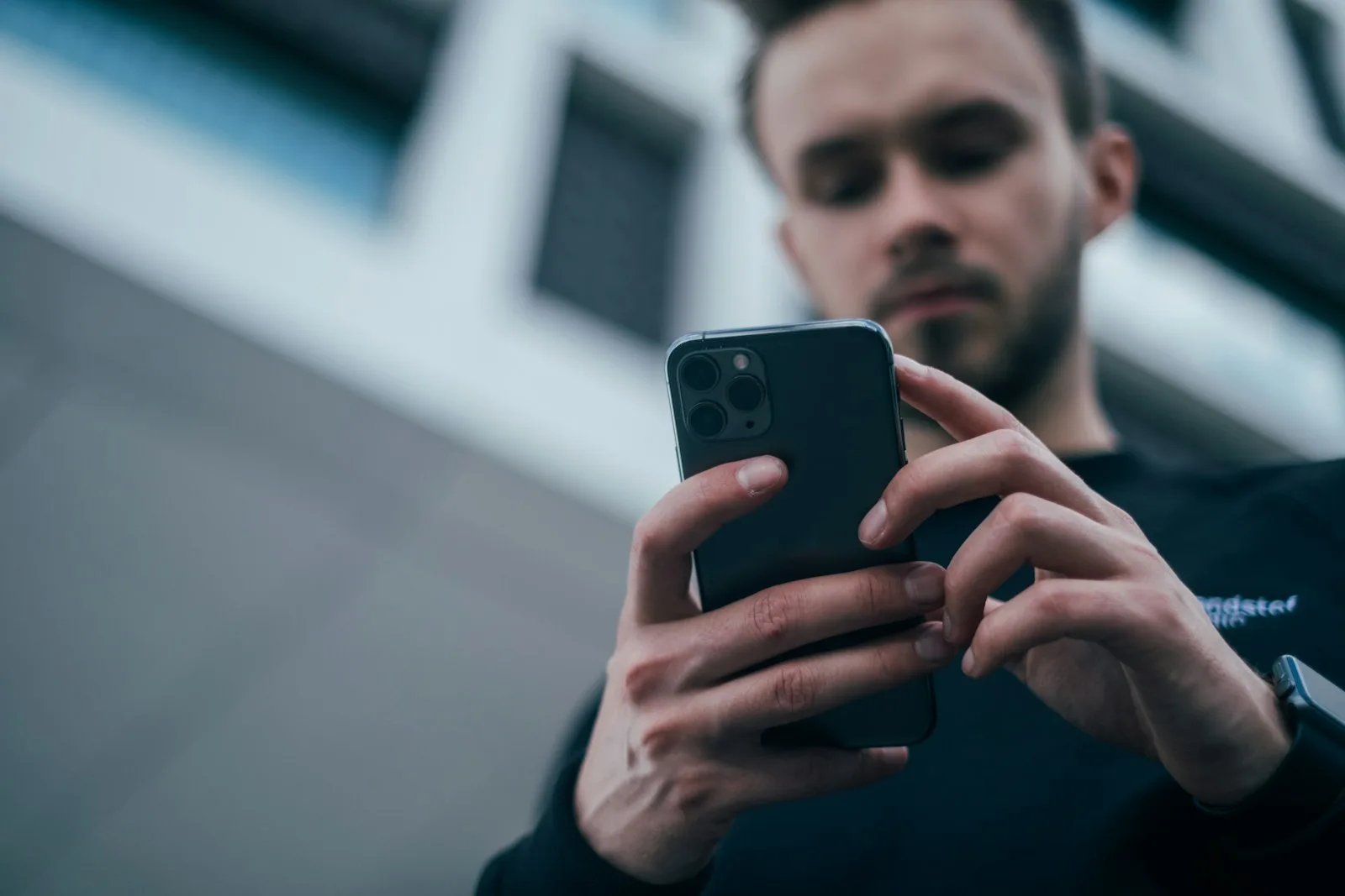 A React Native developer trying a build on his phone, holding it in both hands.