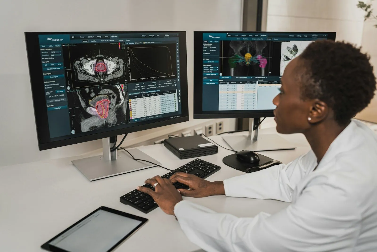 An ML solutions architect in a lab coat analysing scans across two monitors.