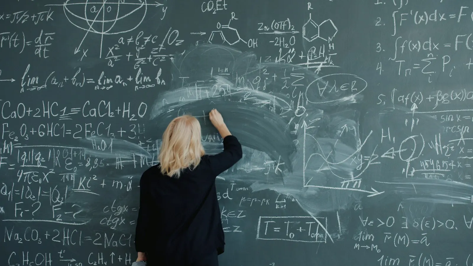A Machine Learning developer working through equations on a chalkboard.
