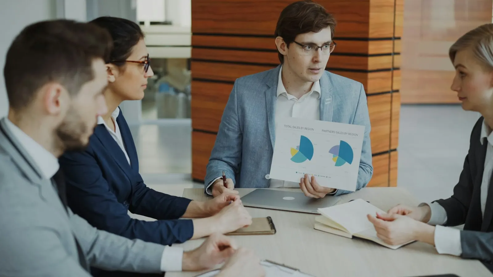 Data Engineers go through warehouse charts together around a meeting table.