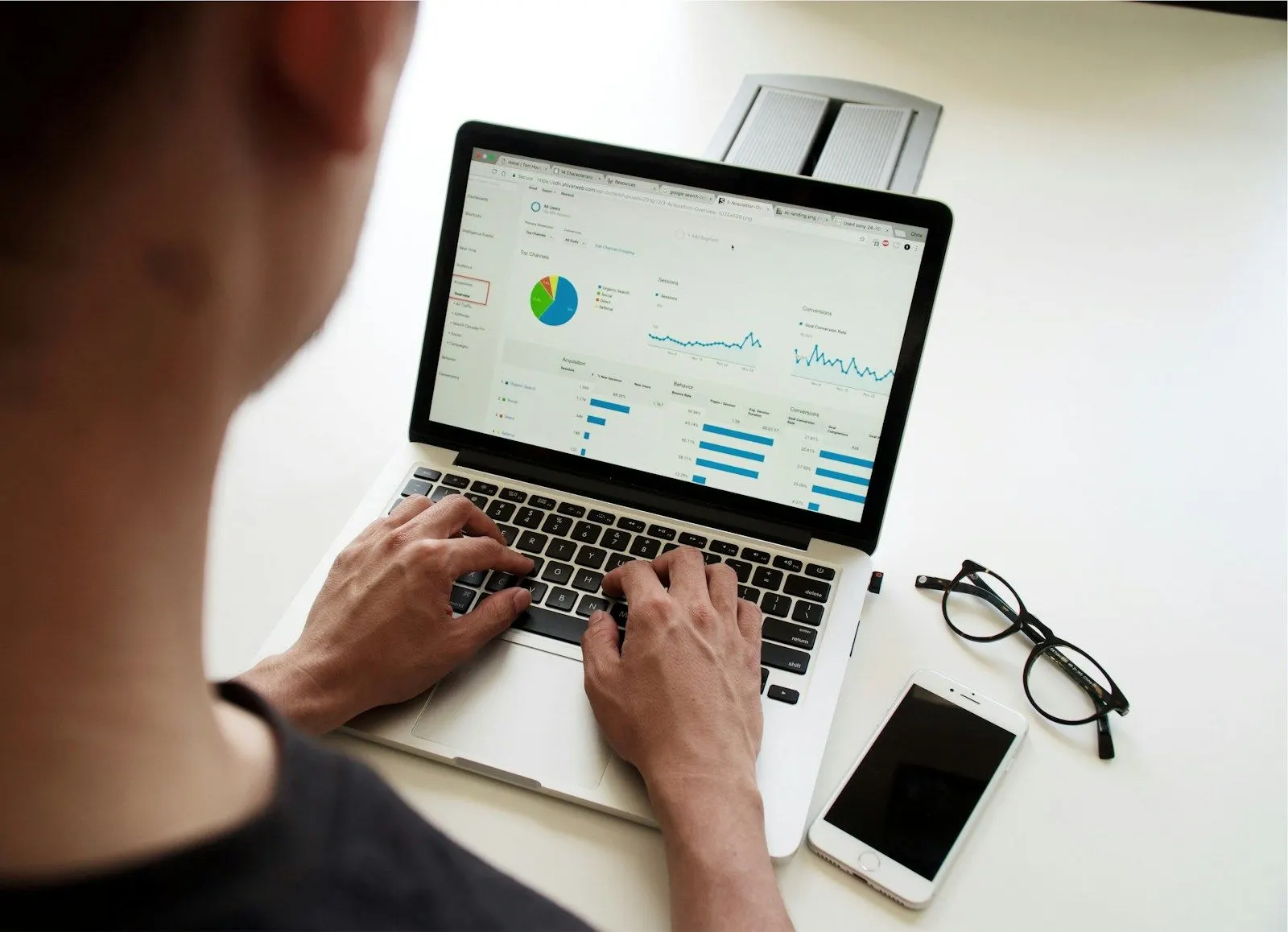 Over-the-shoulder view of a streaming data engineer working through charts on a laptop.