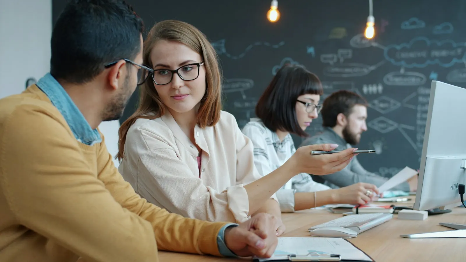 Four Data Engineers work through pipeline results together at a long desk.