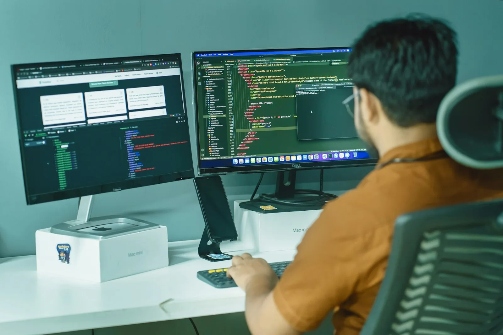A hired QA Automation Engineer reads test code across two monitors.