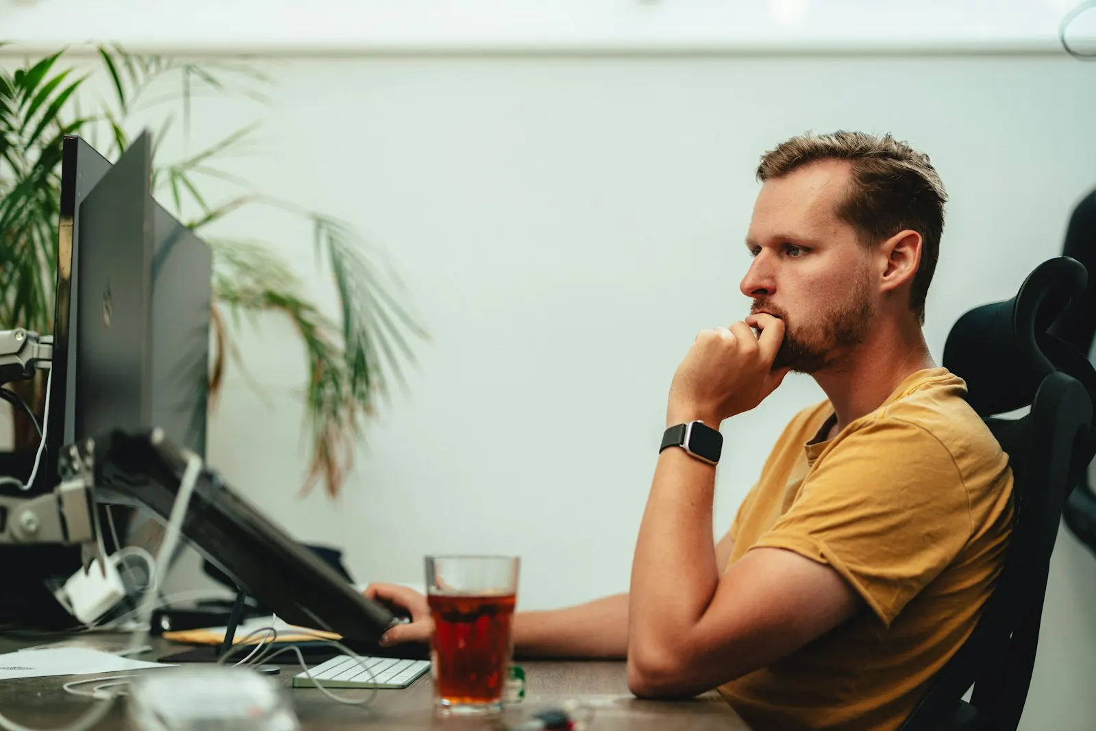 A QA Automation Engineer weighs up a test run at his desk.