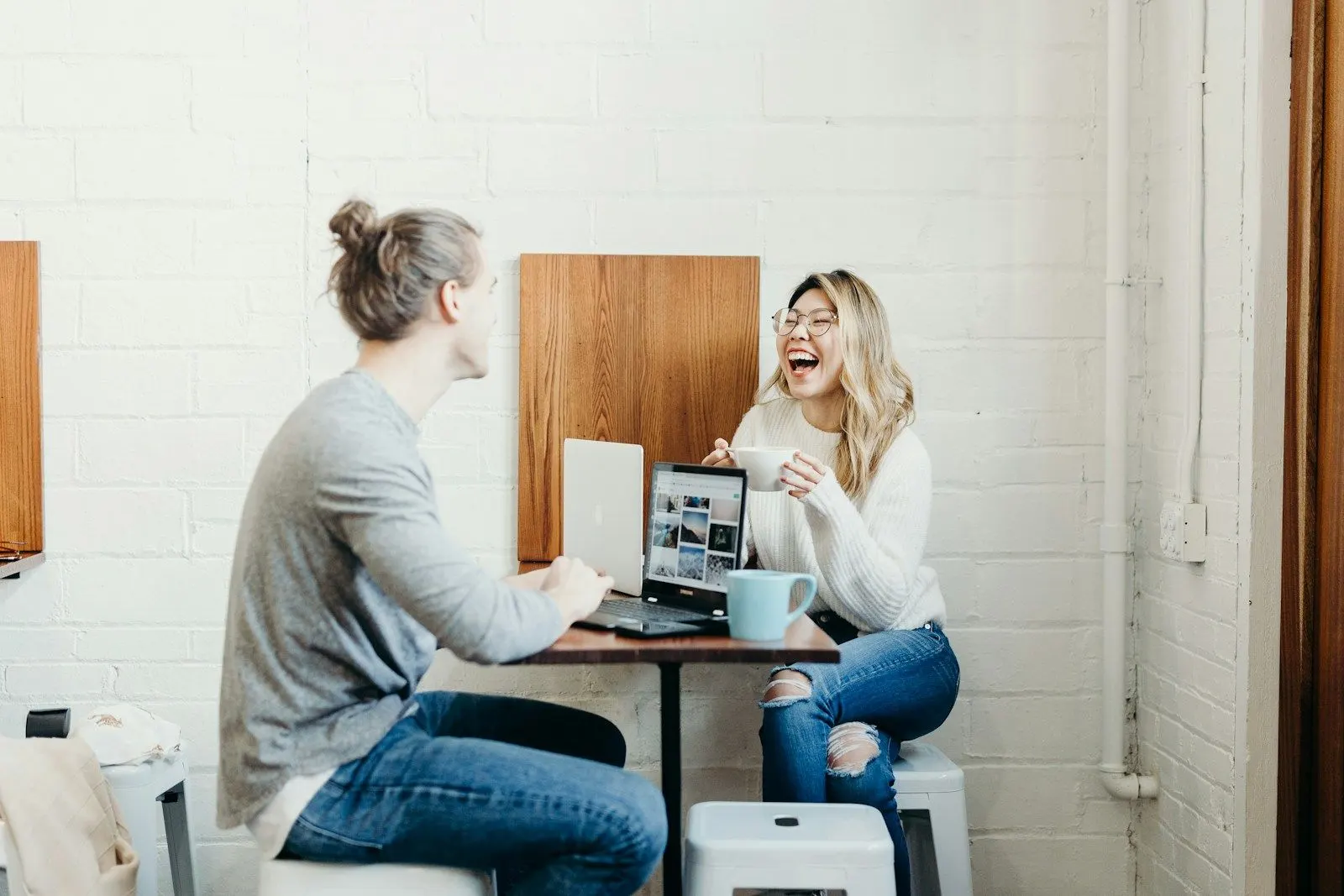 Two QA Automation Engineers work at a laptop in a bright office.