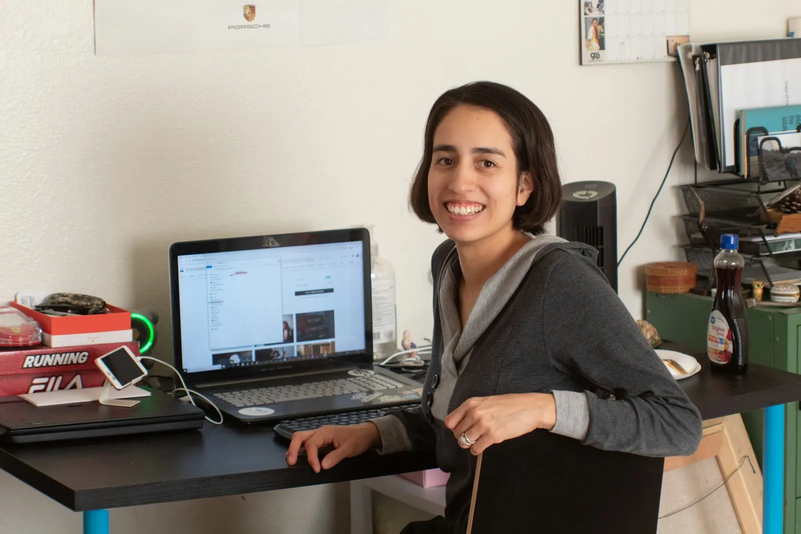 A US onshore mobile developer smiles from her desk beside a laptop.