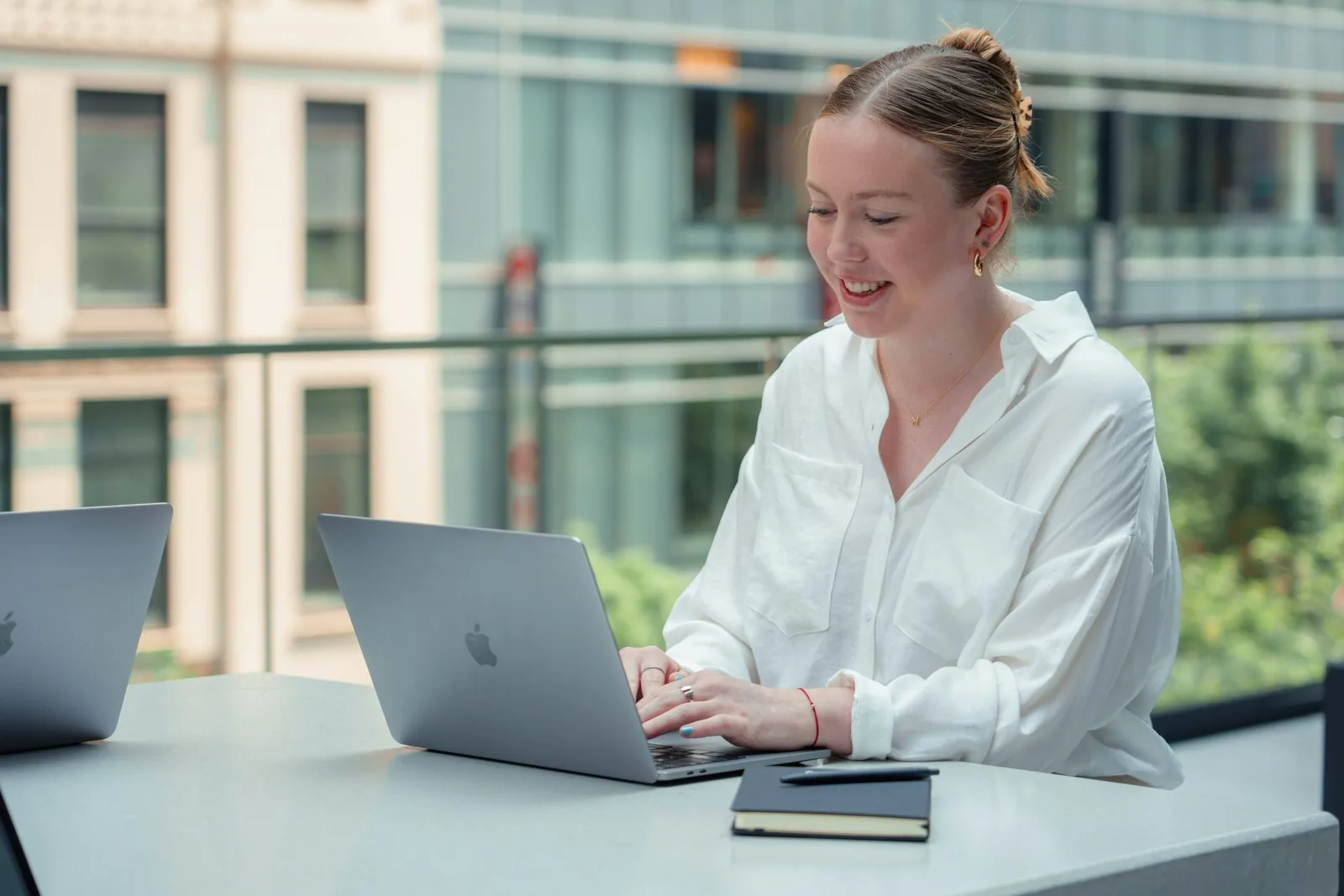 A US onshore developer works at a laptop beside a bright window.