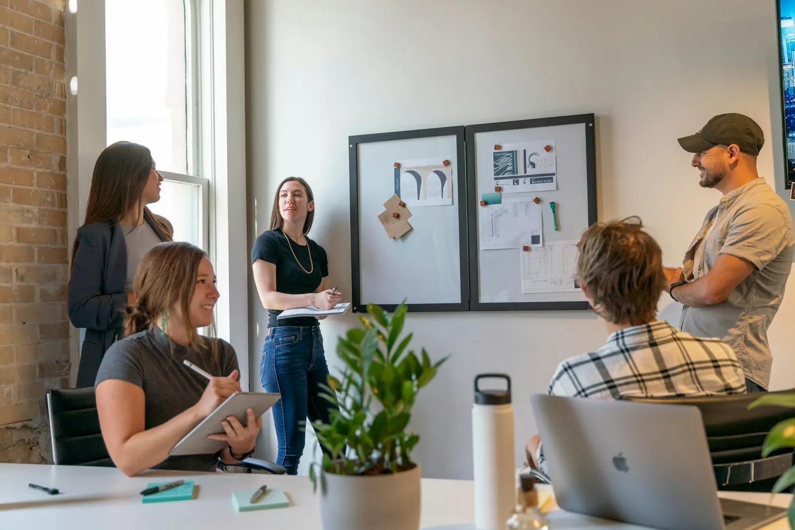 A team gathers around a pinboard to plan its first sprint.