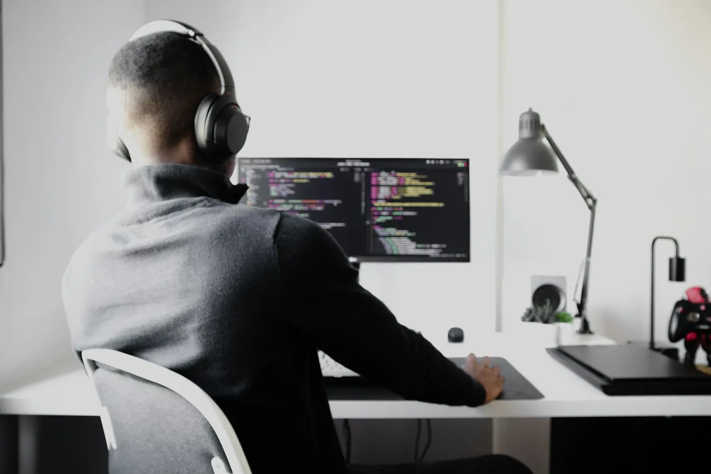 A nearshore DevOps engineer in Mexico works at a desk with a large screen.