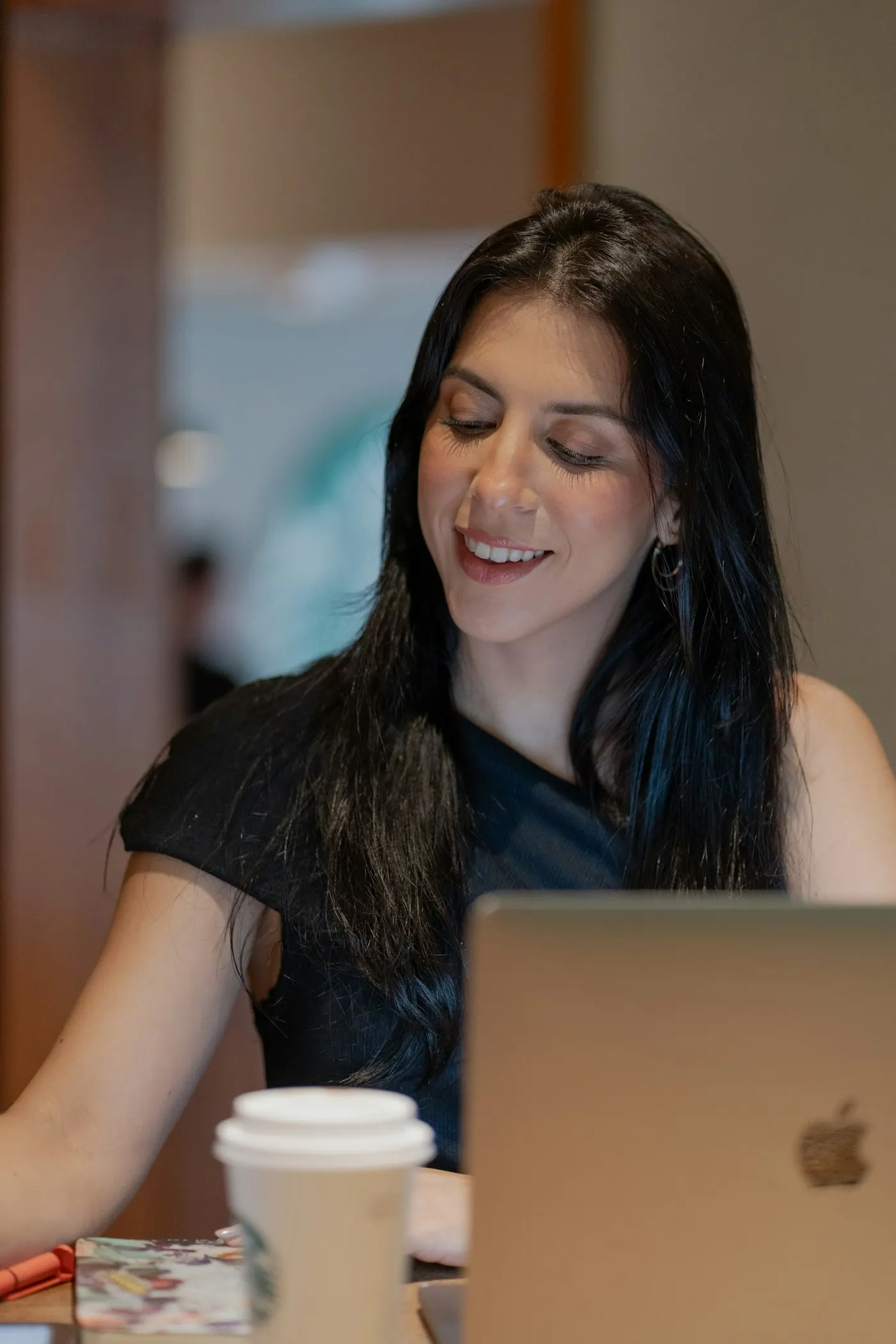 A nearshore mobile developer in Mexico smiles as she works on a laptop.