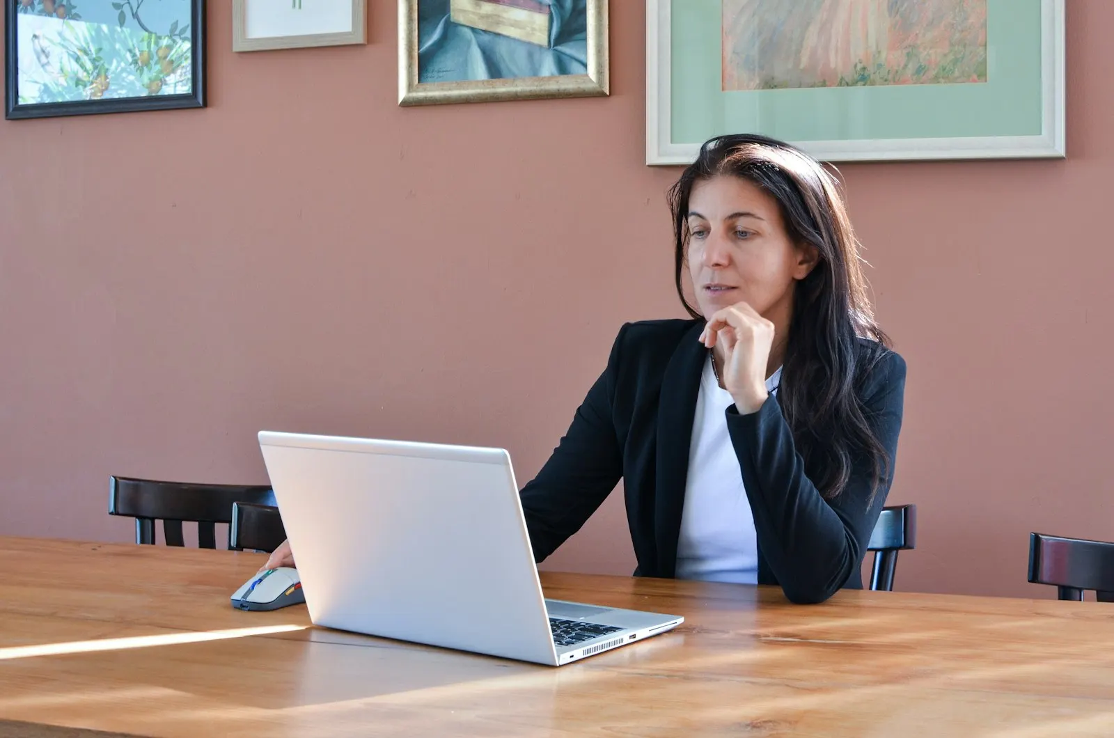 An engineer in a blazer interviews on a call at her laptop.