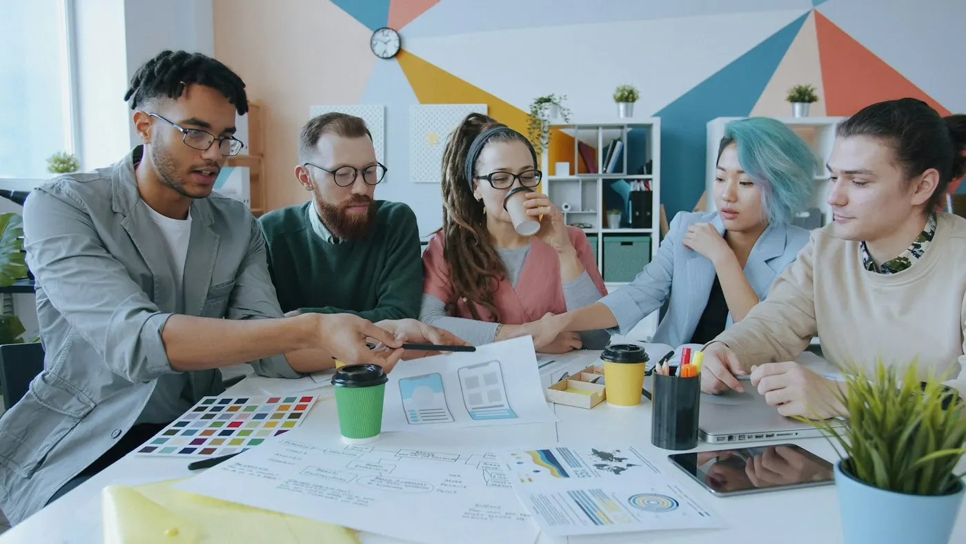 A team reviews profiles and plans around a table.