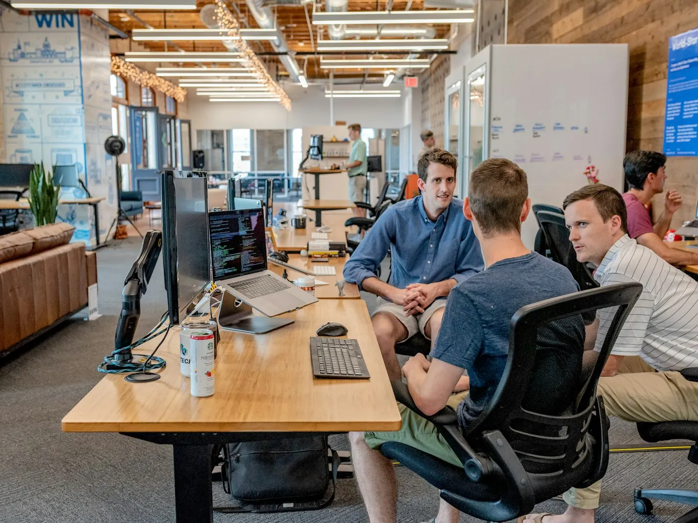 A nearshore product team in Mexico talks through a plan around a desk.