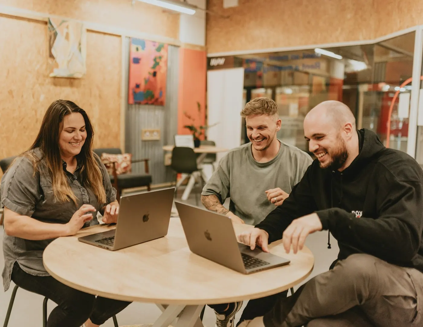 Three nearshore developers in Mexico work through a problem at a shared table.