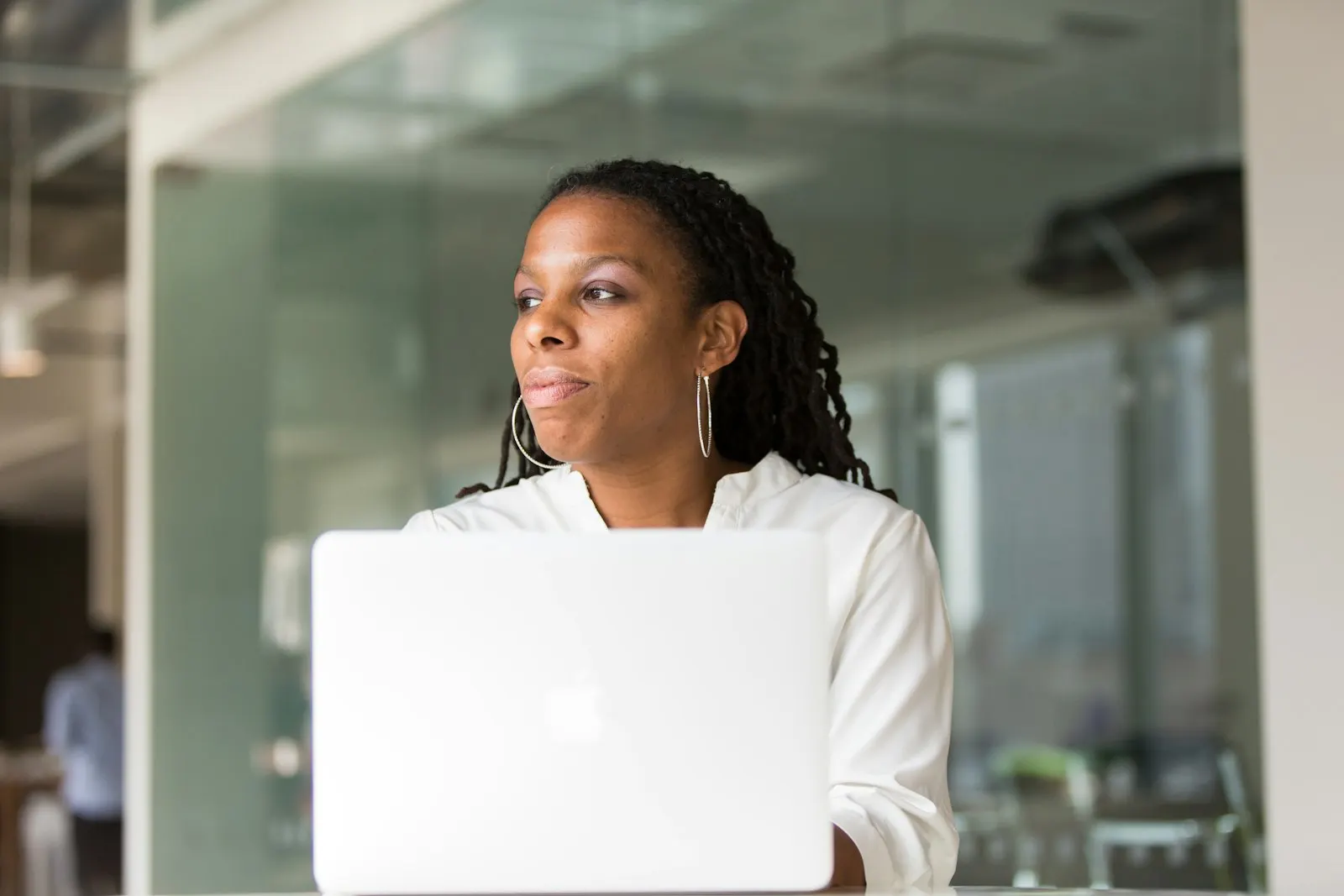 A nearshore mobile developer in Canada looks up from her laptop in a glass-walled office.