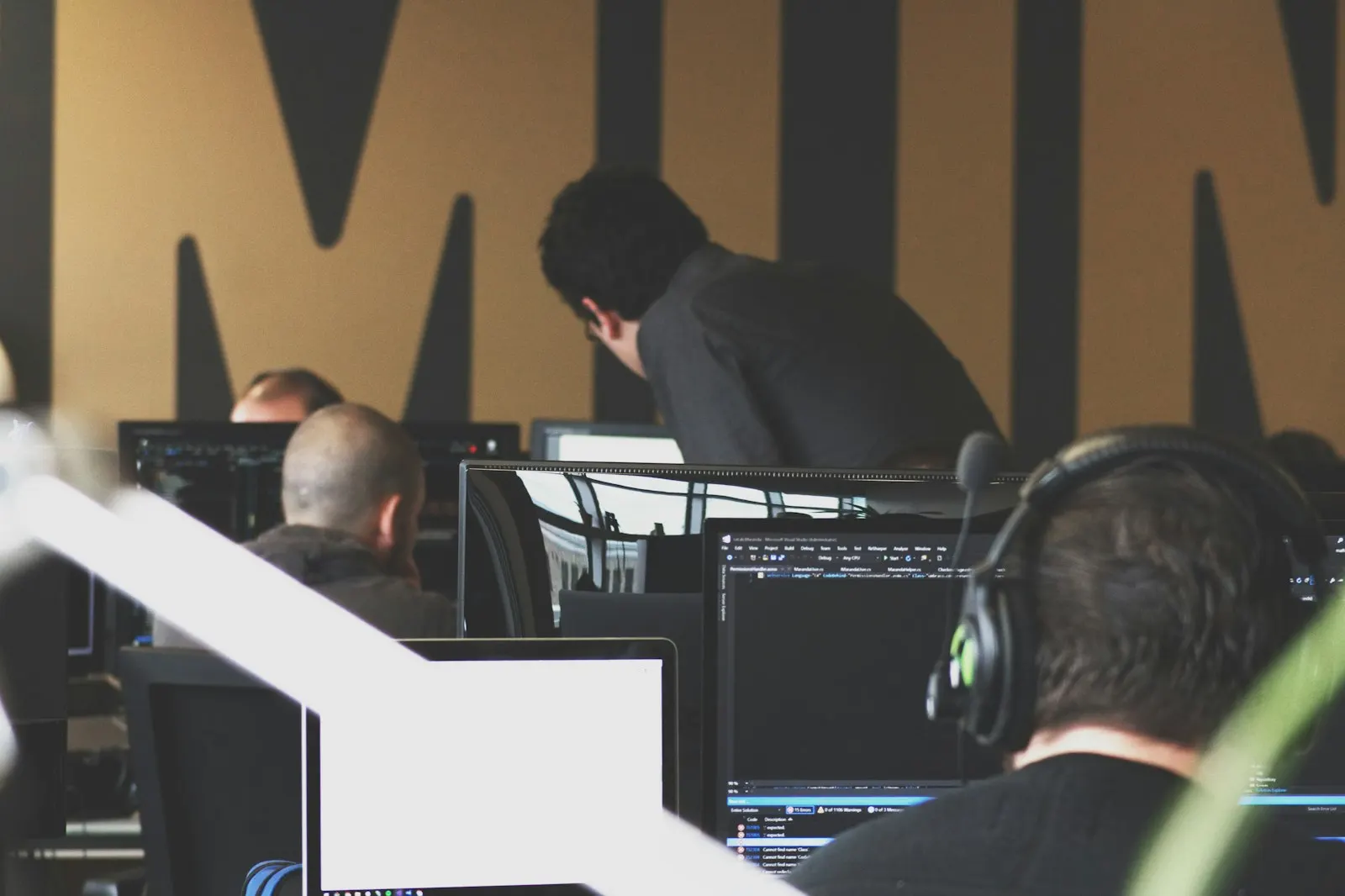 Nearshore developers in Canada work at rows of screens in a shared studio.