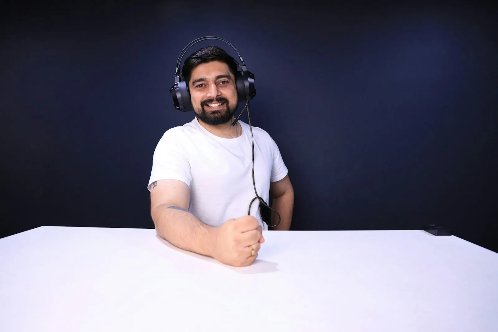 An offshore back-end developer in India sits at a white desk with a headset.
