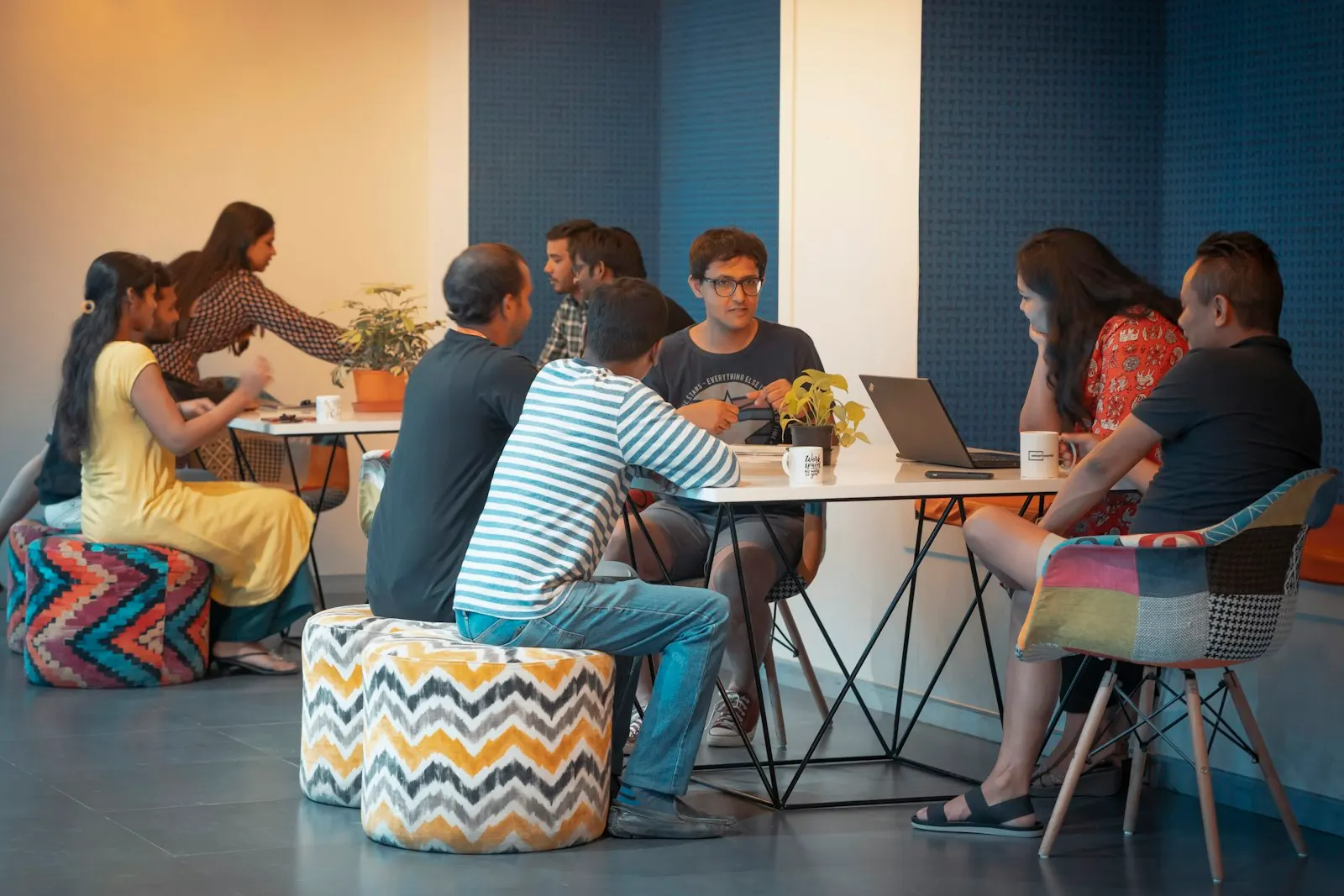 An offshore product team in India talks through its work around a table of laptops.