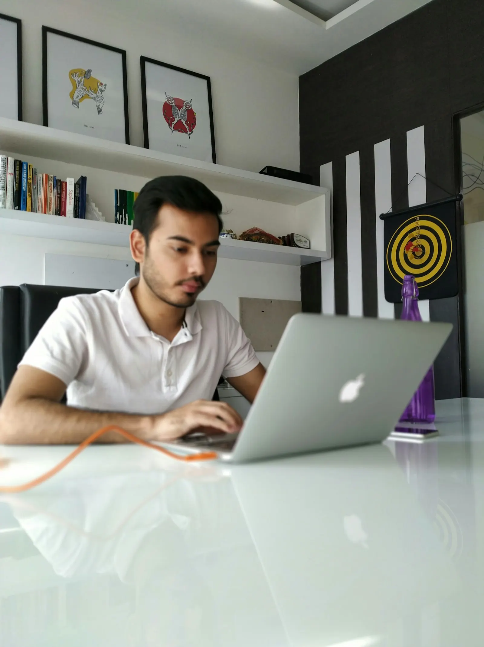 An offshore full-stack developer in India works on a laptop at a white desk.