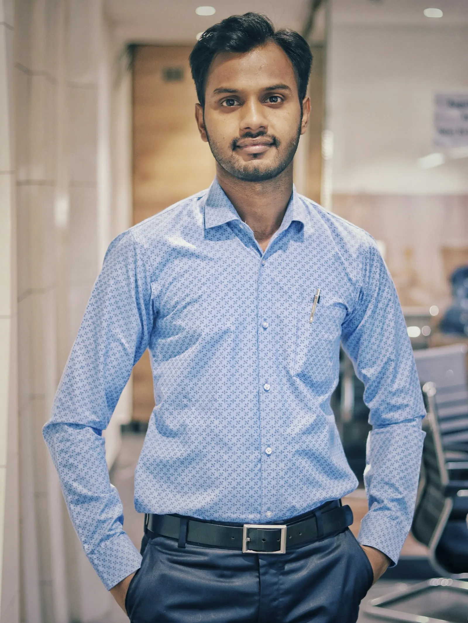 An offshore QA engineer in India stands in an office.