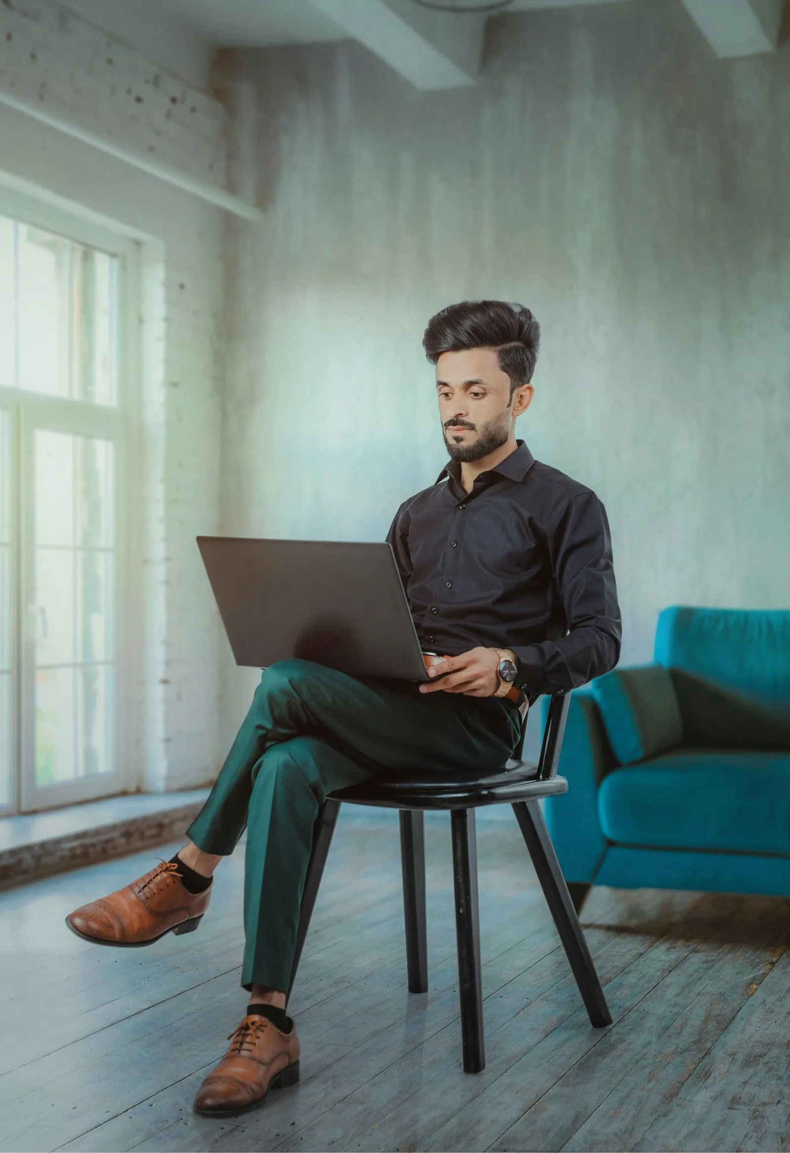 An engineer at a global capability center in India works on a laptop in a bright loft office.