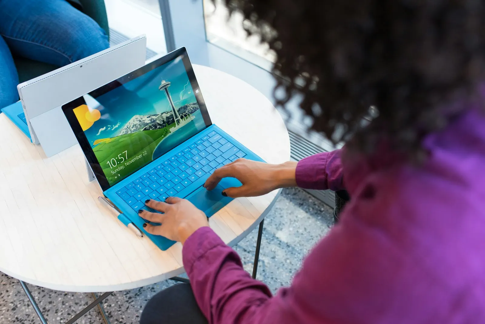 A QA engineer works through an app on a tablet at a bright table.