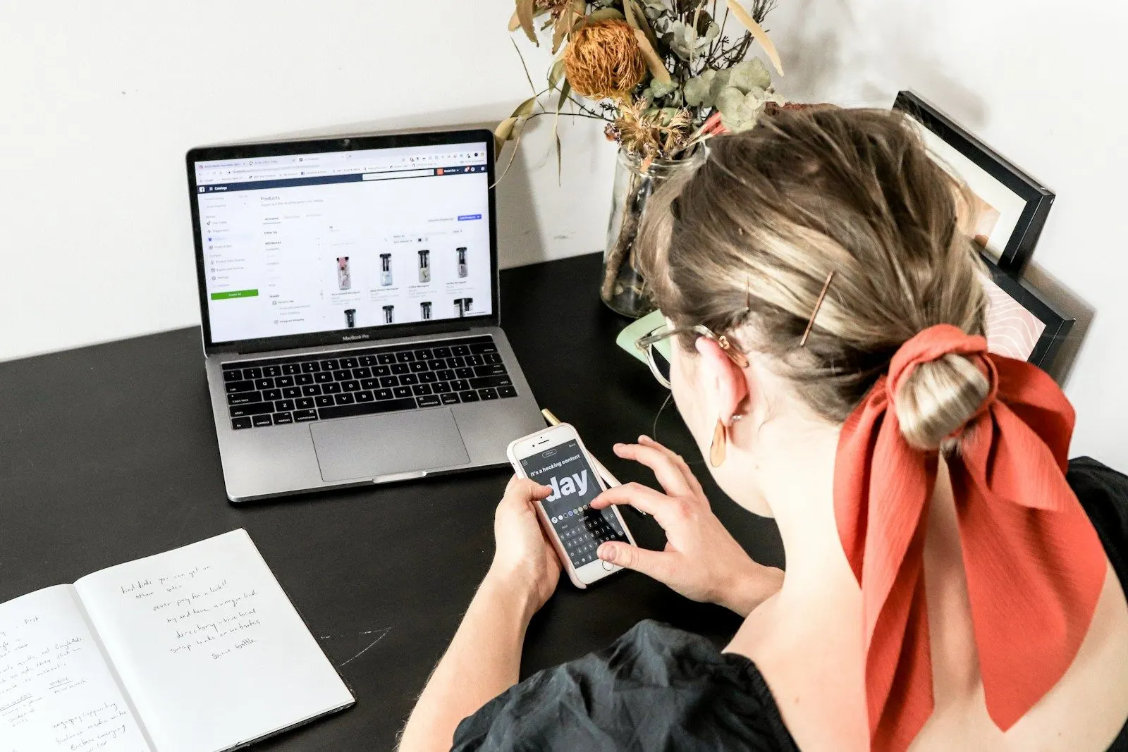A test automation engineer checks an app on her phone against the same screen on her laptop.