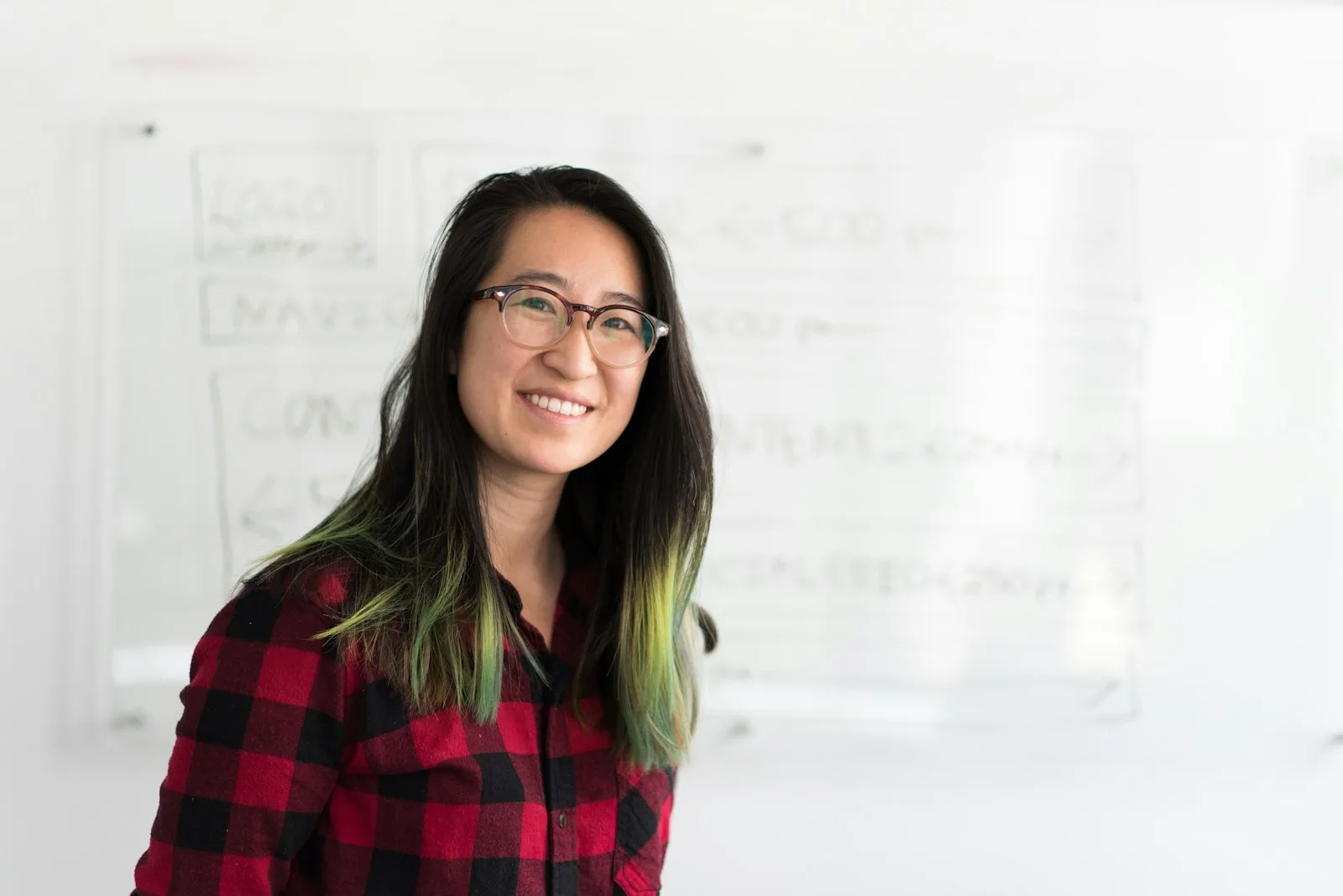 A specialist developer standing in front of a whiteboard of architecture diagrams.