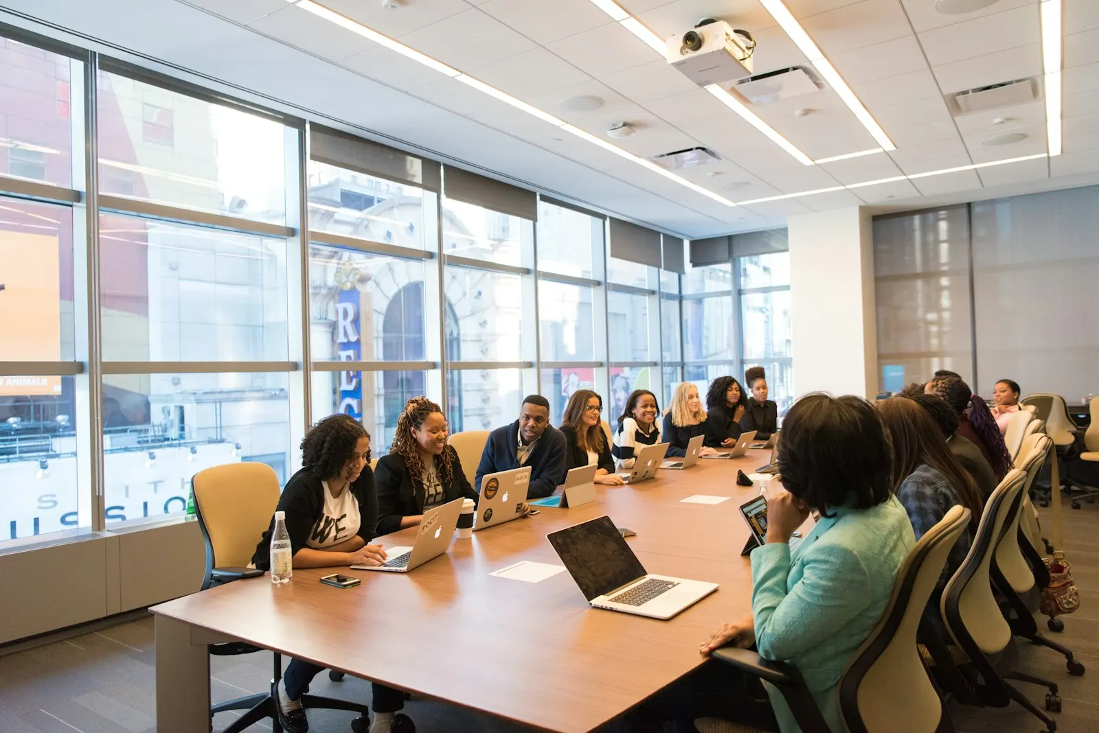A leadership team reviews a product discovery plan around a boardroom table with laptops open.