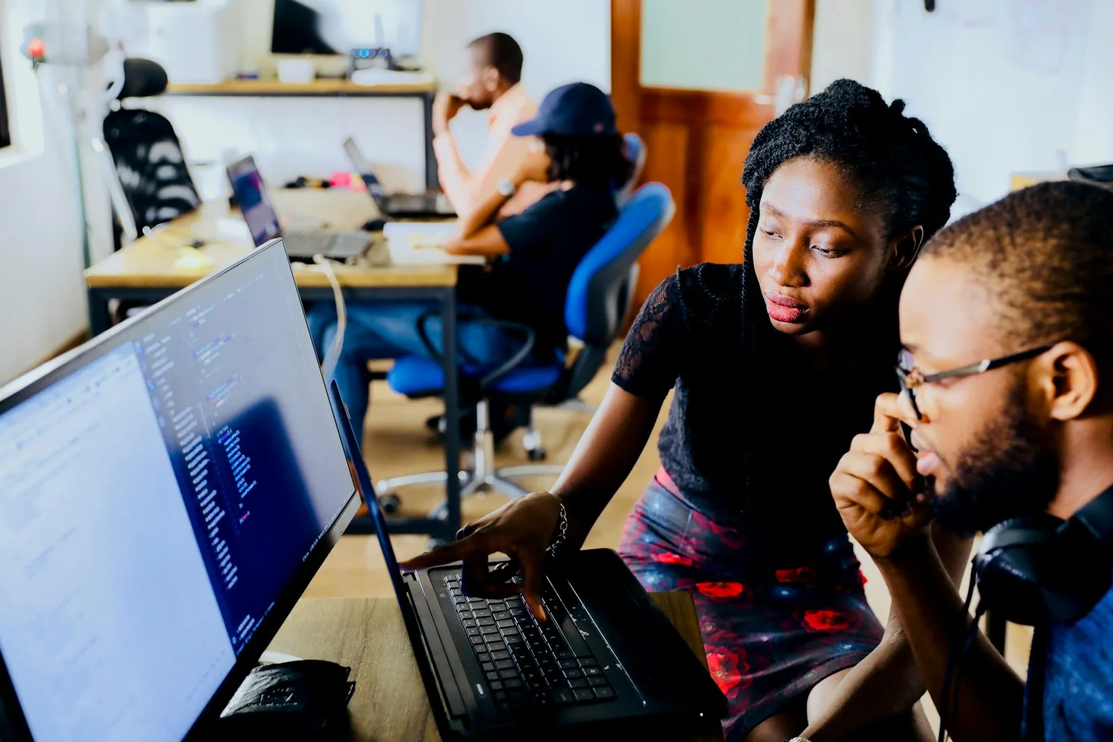 Two colleagues work through a plan together at a screen.